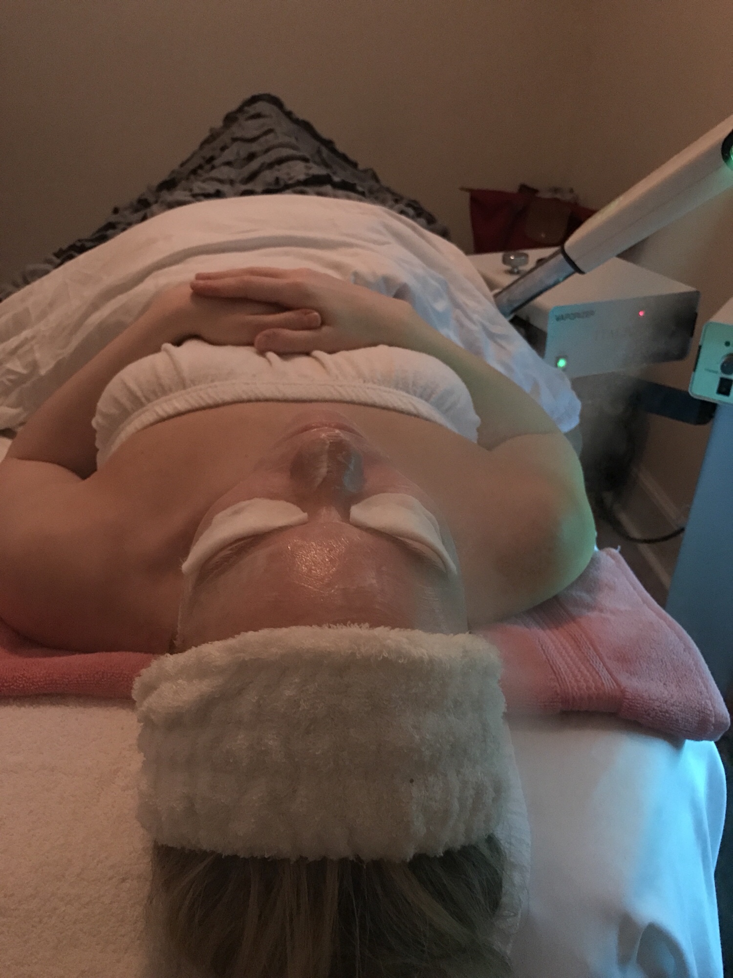 A woman relaxing during a facial treatment